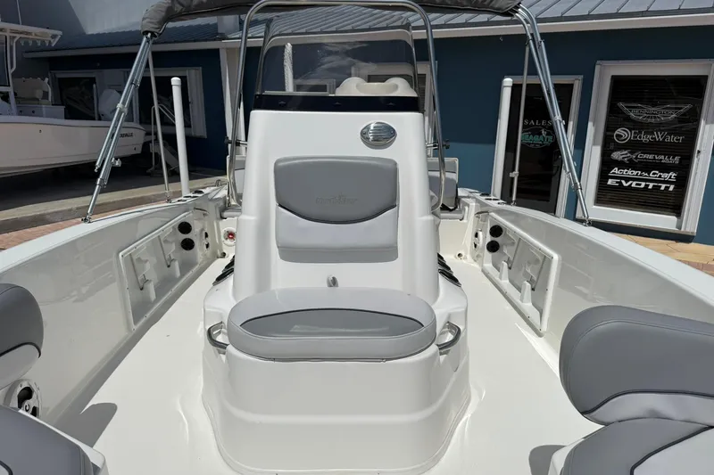 Slide: The Image of 2021 NauticStar 191 Hybrid boat interior with seating and console, displayed outdoors. - 23