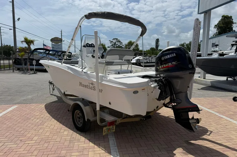 Slide: The Image of 2021 NauticStar 191 Hybrid boat with Yamaha engine on trailer in sunny dealership lot. - 3