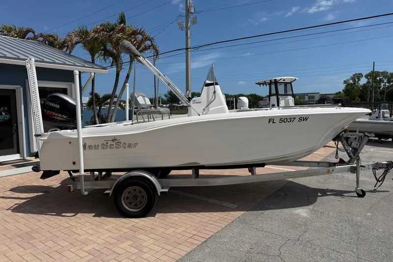 Slide: The Image of 2021 NauticStar 191 Hybrid boat on trailer, parked outdoors under clear sky. - 6