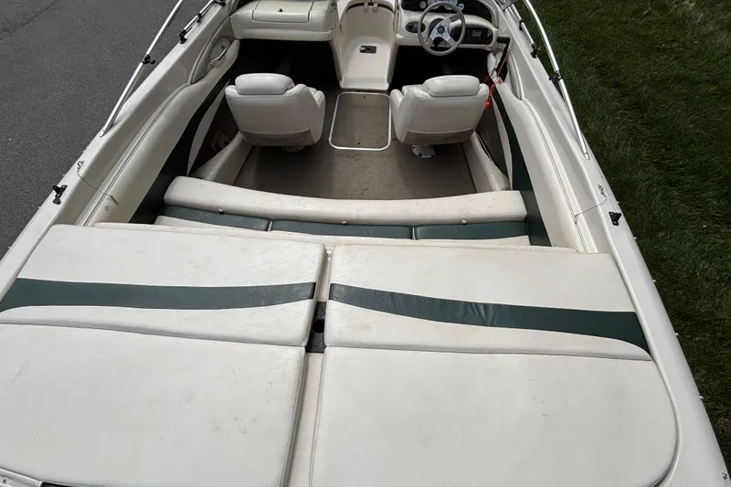 Slide: The Image of 2001 Larson 210 I/O boat interior with white and green seating, steering wheel visible. - 10