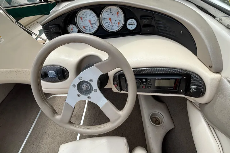 Slide: The Image of Steering wheel and dashboard of a 2001 Larson 210 I/O boat, featuring gauges and controls. - 8