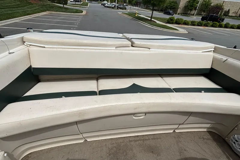 Slide: The Image of Interior seating of a 2001 Larson 210 I/O boat in a parking lot. - 9
