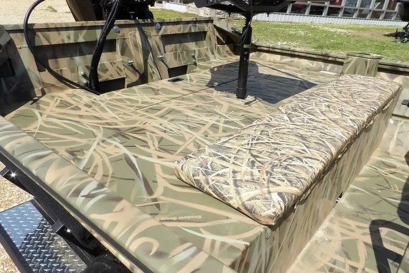 Slide: The Image of Camo-patterned interior of 2026 Crestliner 1760 Retriever FCC boat, featuring bench seating. - 13