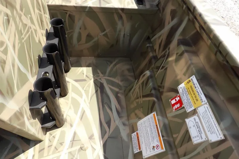 Slide: The Image of Interior of 2026 Crestliner 1760 Retriever FCC with camouflage design and rod holders. - 24