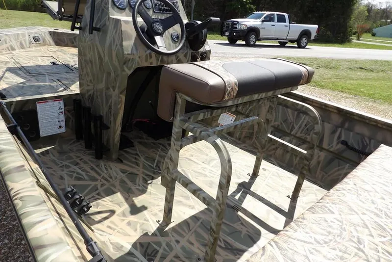 Slide: The Image of 2026 Crestliner 1760 Retriever FCC boat interior with camo design and steering console. - 3