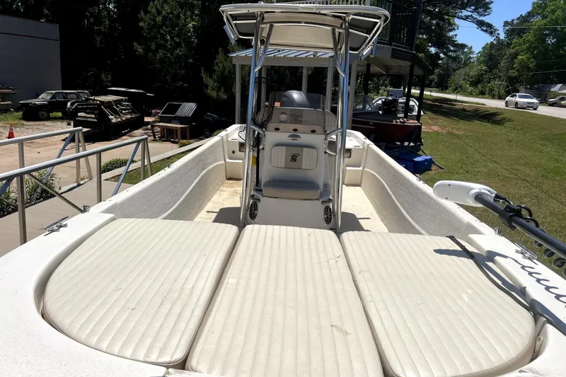 Slide: The Image of 2018 Carolina Skiff 258 DLV boat with spacious deck and center console, parked outdoors. - 4