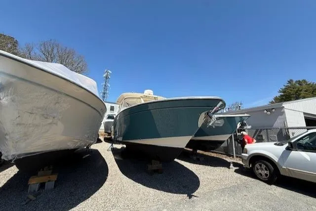 The Image of 2018 Grady-White Freedom 325 boat in storage, alongside other vessels and a vehicle. - 1
