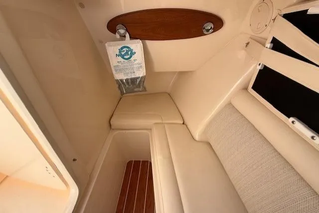 Slide: The Image of 2018 Grady-White Freedom 325 cabin interior with beige seating and wooden accents. - 13