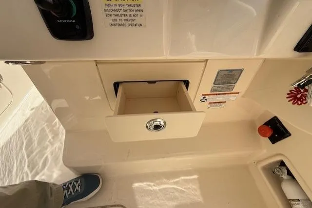 Slide: The Image of Control panel and storage compartment on a 2018 Grady-White Freedom 325 boat. - 34