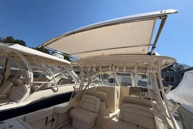 Slide: The Image of 2018 Grady-White Freedom 325 boat interior with seating and canopy under clear blue sky. - 42