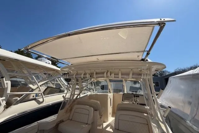 Slide: The Image of 2018 Grady-White Freedom 325 boat interior with seating and canopy under clear blue sky. - 43