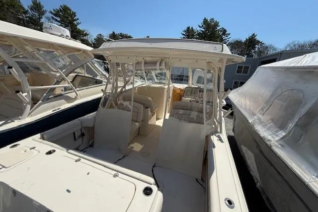 Slide: The Image of 2018 Grady-White Freedom 325 boat with spacious seating, docked outdoors under clear skies. - 6