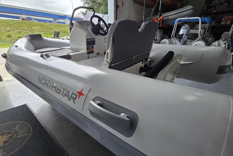 Slide: The Image of 2026 Northstar Vega 3.8 inflatable boat with Tohatsu 30HP engine in showroom. - 2