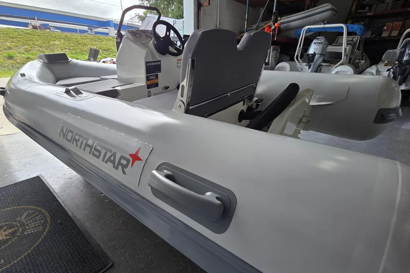 Slide: The Image of 2026 Northstar Vega 3.8 inflatable boat with Yamaha 25HP engine in showroom. - 2