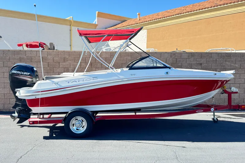 The Image of 2016 Tahoe 550 TF boat with red hull and Mercury outboard motor on trailer. - 0