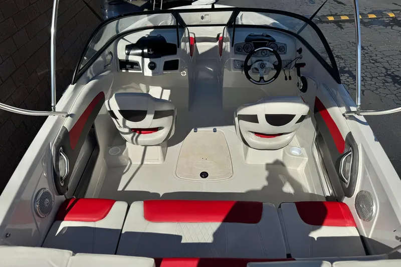 Slide: The Image of 2016 Tahoe 550 TF boat interior with red and white seating, steering wheel, and dashboard. - 11