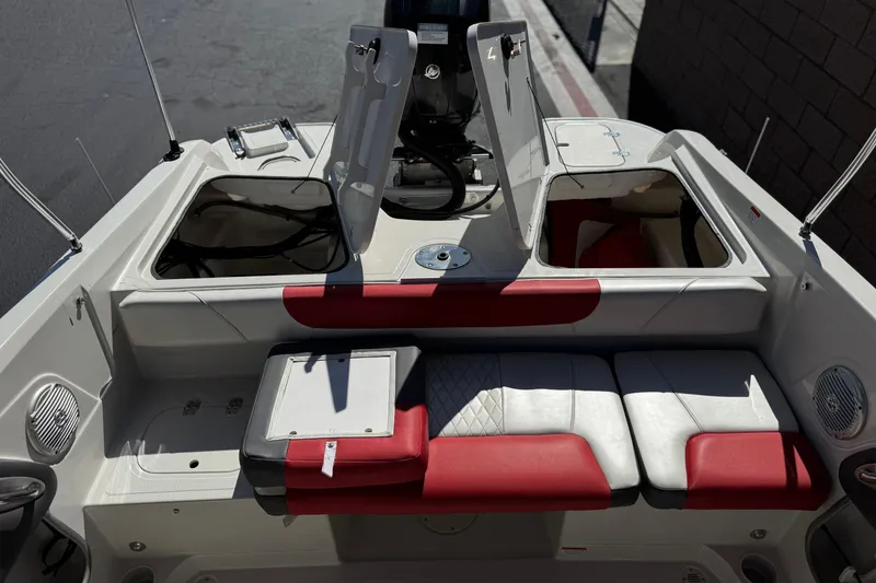 Slide: The Image of 2016 Tahoe 550 TF boat interior with red and white seating and open storage compartments. - 21