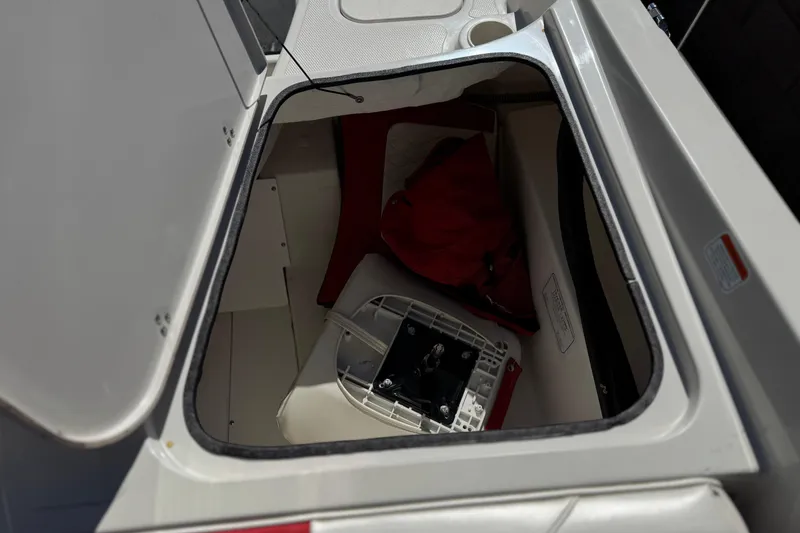 Slide: The Image of Open storage compartment in a 2016 Tahoe 550 TF boat, containing equipment and a red bag. - 23