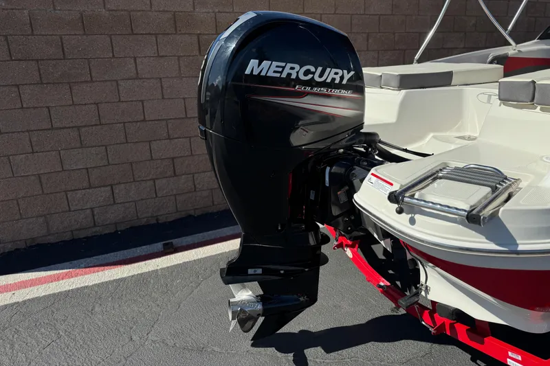 Slide: The Image of Mercury FourStroke engine on 2016 Tahoe 550 TF boat, parked on pavement. - 6