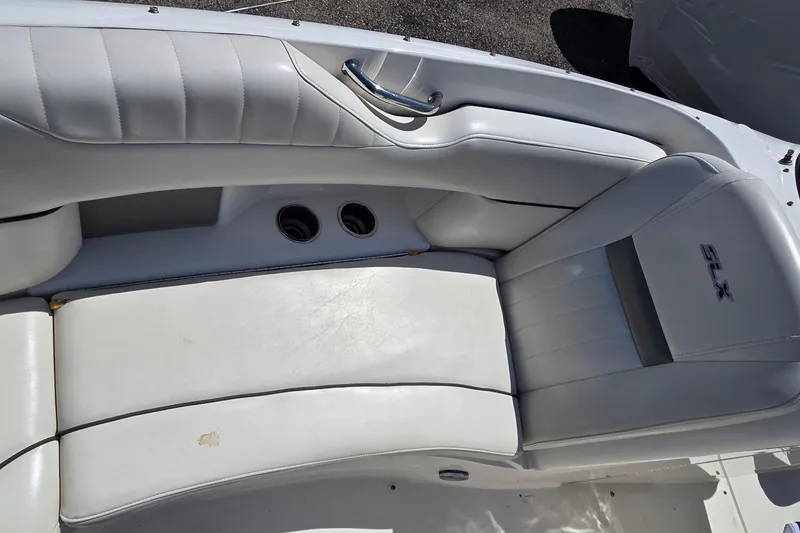 Slide: The Image of White leather seating on a 2007 Sea Ray SLX 250 boat, featuring cup holders and sleek design. - 8