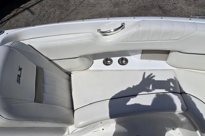 Slide: The Image of Interior seating of a 2007 Sea Ray SLX 250 boat with white upholstery and cup holders. - 9