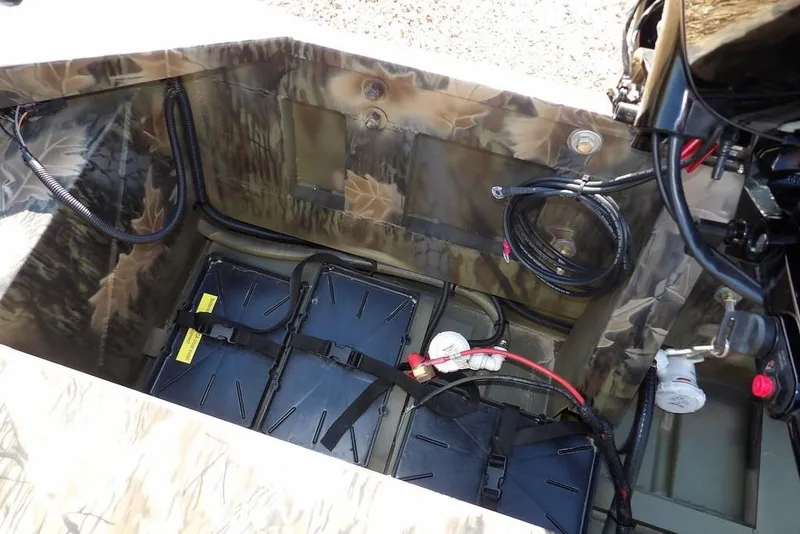 Slide: The Image of Interior view of 2026 Crestliner 1860 Retriever Deluxe boat showing battery compartment and wiring. - 16