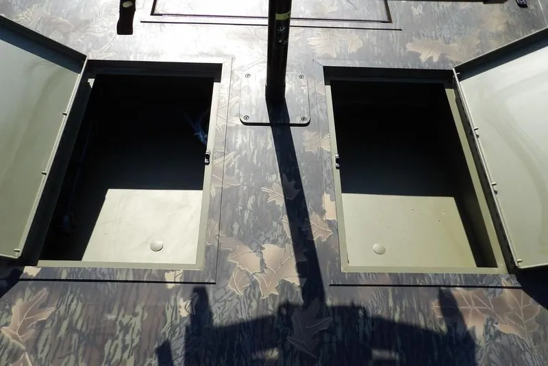 Slide: The Image of Open storage compartments on 2026 Crestliner 1860 Retriever Deluxe boat with camouflage pattern. - 28