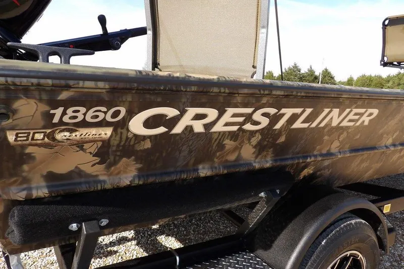 Slide: The Image of 2026 Crestliner 1860 Retriever Deluxe boat with camouflage design on a trailer. - 30