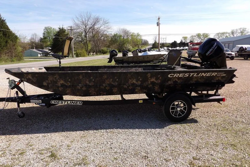 Slide: The Image of 2026 Crestliner 1860 Retriever Deluxe boat on trailer, camo design, parked outdoors. - 4