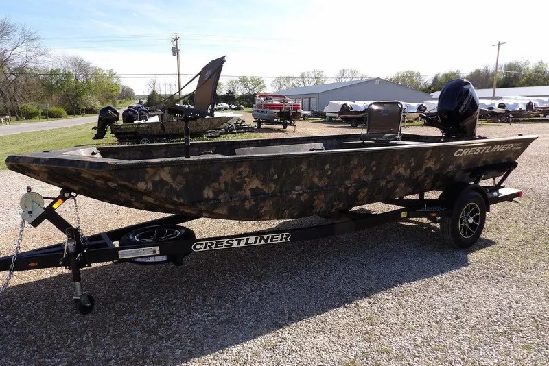 Slide: The Image of 2026 Crestliner 1860 Retriever Deluxe boat on trailer, camo design, parked outdoors. - 5