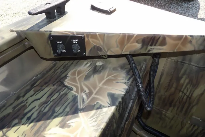 Slide: The Image of Interior of 2026 Crestliner 1860 Retriever Deluxe with camouflage design and control switches. - 8