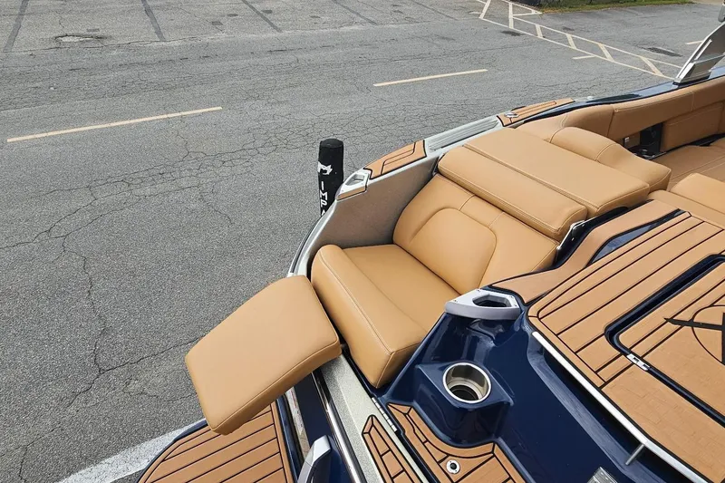 Slide: The Image of 2020 MasterCraft X24 boat with tan seating and sleek design in a parking area. - 26