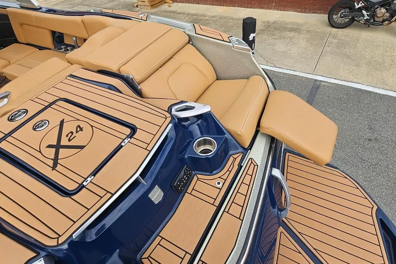 Slide: The Image of 2020 MasterCraft X24 boat with tan seating and sleek blue deck design. - 27