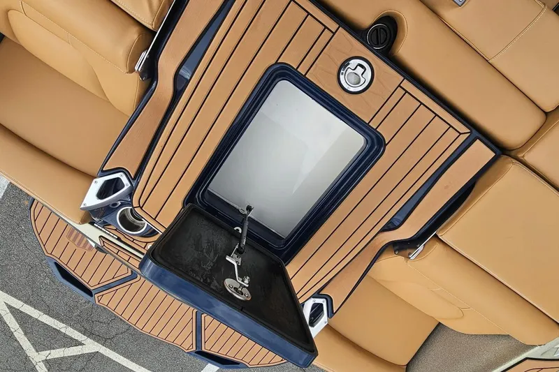 Slide: The Image of 2020 MasterCraft X24 boat interior with tan seating and storage compartment. - 30