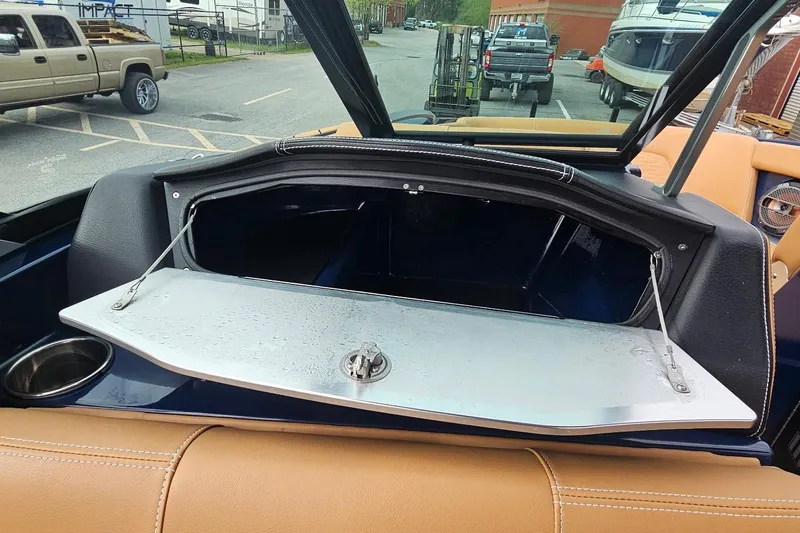 Slide: The Image of Open storage compartment in a 2020 MasterCraft X24 boat, showing interior details. - 32