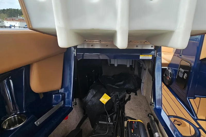 Slide: The Image of Interior storage compartment of a 2020 MasterCraft X24 boat, featuring blue and tan accents. - 33