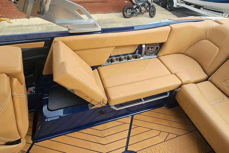 Slide: The Image of 2020 MasterCraft X24 boat interior with tan leather seating and cup holders. - 35