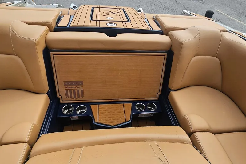 Slide: The Image of 2020 MasterCraft X24 boat interior with tan leather seating and cup holders. - 38