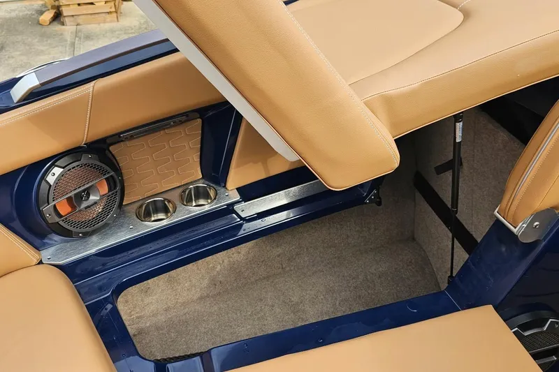 Slide: The Image of 2020 MasterCraft X24 boat interior with tan seats, speaker, and cup holders. - 46