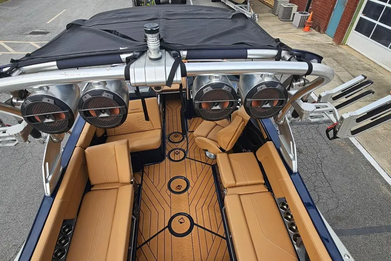 Slide: The Image of 2020 MasterCraft X24 boat interior with tan seating, premium speakers, and stylish flooring. - 48