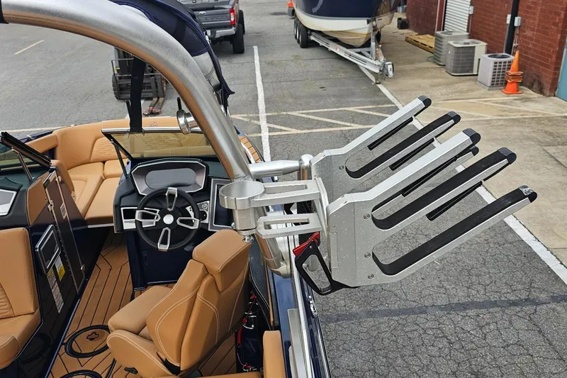 Slide: The Image of 2020 MasterCraft X24 boat interior with wakeboard rack and tan seating. - 49
