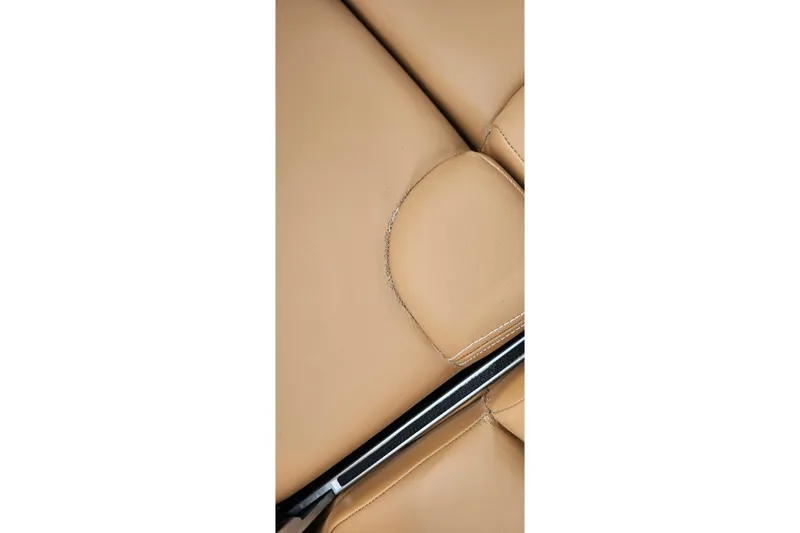 Slide: The Image of Close-up of tan leather upholstery in a 2020 MasterCraft X24 boat. - 52