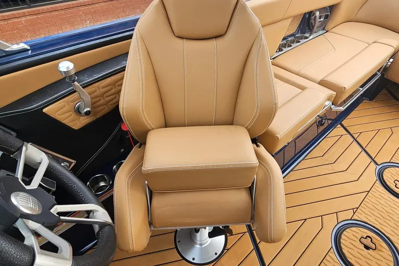 Slide: The Image of 2020 MasterCraft X24 boat interior with tan leather seating and modern steering wheel. - 56
