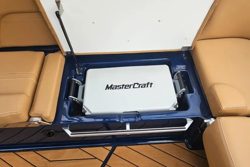 Slide: The Image of 2020 MasterCraft X24 boat interior with storage compartment and tan seating. - 63