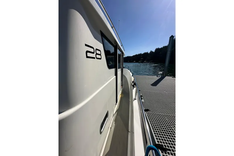 The Image of 2018 Sargo 25 boat docked in clear water, surrounded by lush greenery. - 0