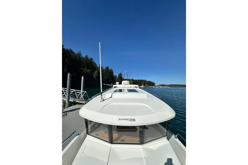 Slide: The Image of 2018 Sargo 25 boat docked by a scenic forested shoreline. - 10