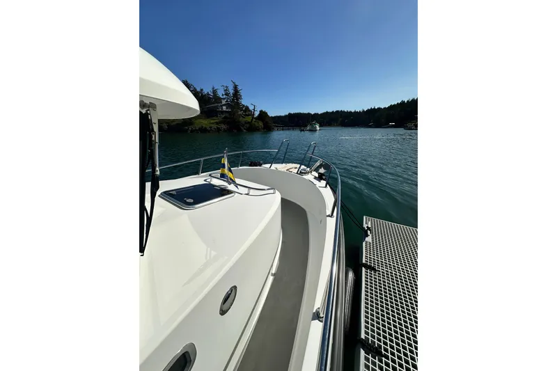 Slide: The Image of 2018 Sargo 25 boat docked on a sunny day by a scenic shoreline. - 12