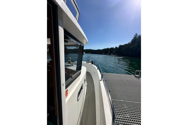 Slide: The Image of 2018 Sargo 25 boat docked by a scenic lake under clear blue skies. - 14