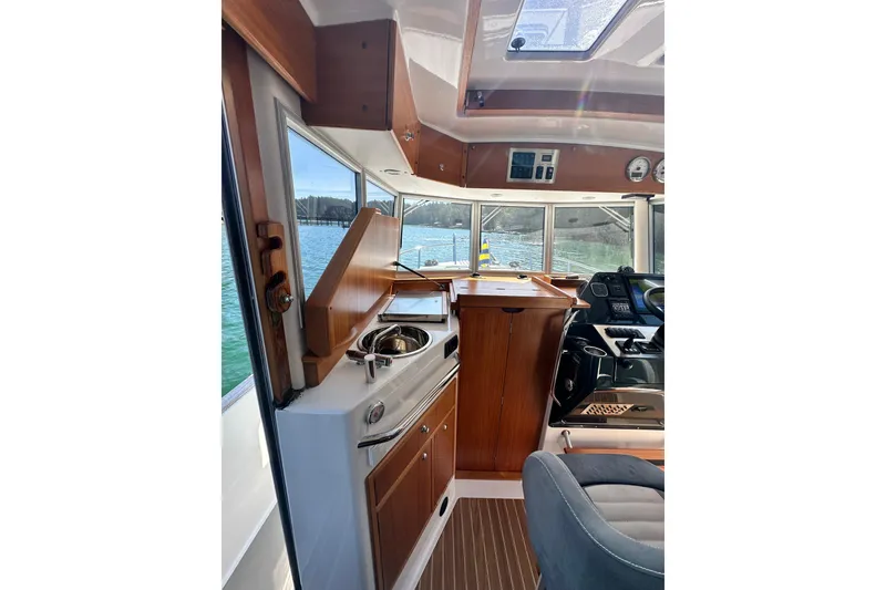 Slide: The Image of Interior of 2018 Sargo 25 boat with wooden cabinetry and helm station. - 16