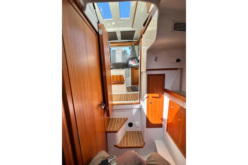 Slide: The Image of Interior of 2018 Sargo 25 boat, featuring wooden cabinetry and steps. - 22